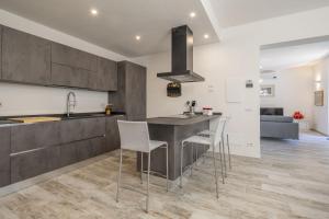a kitchen with a bar with chairs and a sink at Villetta Cafaggio, Ac, Wifi, Panzano In Chianti in Castellina in Chianti