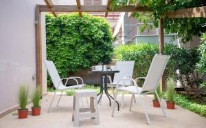 a patio with white chairs and a table at Cozy Boutique in Vrachati