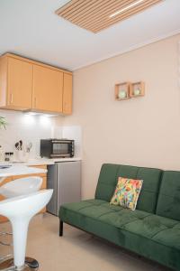 a living room with a green couch in a kitchen at Cozy Boutique in Vrahati