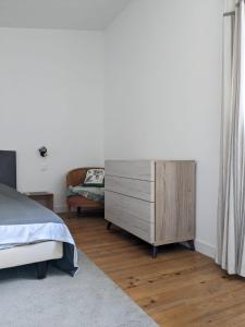 a bedroom with a dresser and a bed and a couch at Maison au pied du château, terrasse in Grignan