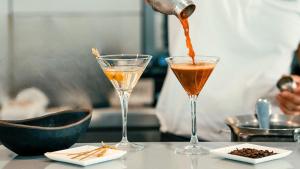 a person pouring a drink into two glasses on a table at Labranda Marieta & Spa - Adults Only in Playa del Ingles