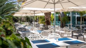 a group of tables with white chairs and umbrellas at Labranda Marieta & Spa - Adults Only in Playa del Ingles