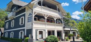 a blue and white house with flowers on the balcony at Pension Linder in Seeboden
