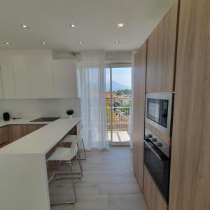a kitchen with a counter and a tv on a wall at Tonfano Waterfront Penthouse in Marina di Pietrasanta
