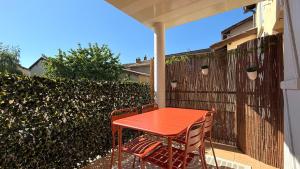 a red table and two chairs on a patio at Les Arches Beaujolaises in Belleville-en-Beaujolais