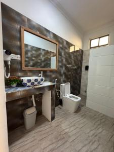a bathroom with a toilet and a sink and a mirror at Jambo Resort by Mambo Hotels in Paje +99 photos