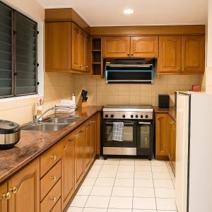 a kitchen with wooden cabinets and a stove top oven at Elegant 2BR Manila Bay Sunset near US Embassy in Manila
