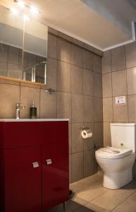 a bathroom with a toilet and a sink and a mirror at Kouros City Center in Kavala +57 photos