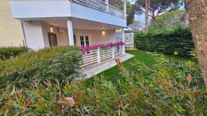 a house with a white fence and pink flowers at Pines House in Draç
