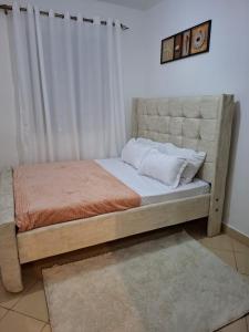 - une chambre avec un lit doté d'une grande tête de lit dans l'établissement The Cozy house, à Nairobi