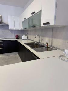 a kitchen with white cabinets and a sink at 3 Bedrm Penthouse Amazing Views in St Paul's Bay