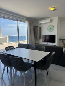 a dining room and living room with a table and chairs at 3 Bedrm Penthouse Amazing Views in St Paul's Bay