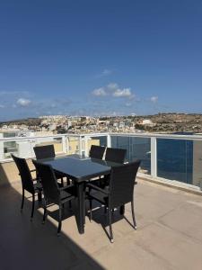 a table and chairs on a balcony with a view of the ocean at 3 Bedrm Penthouse Amazing Views in St Paul's Bay +17 photos
