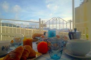 a table with pastries and glasses on a balcony at Casa Il Timone Indipendente in Ponza