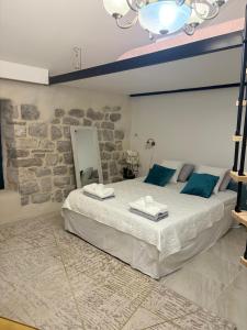 a bedroom with a large bed with blue pillows at Casa Behar in Kotor