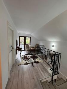 an empty living room with a staircase and a table at Casa Luminița in Vama Buzăului +19 photos