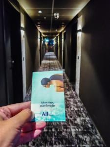 a person holding up a sign in a hallway at ibis Bucharest Politehnica in Bucharest