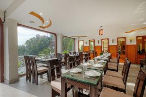a dining room with tables and chairs and a large window at Pax Hotel Spring Solance 200 mtr from Gandhi Chowk Khajjiyar Road in Dalhousie