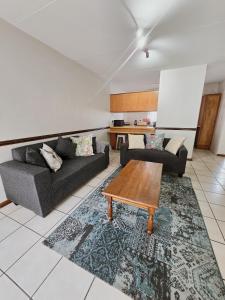 a living room with two couches and a coffee table at Cozy secure apartment in Bloemfontein