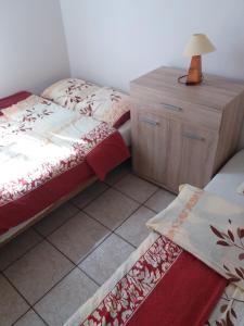 una camera con 2 letti e un comò con una lampada di Domki letniskowe Reda a Rusinowo Altre 64 foto