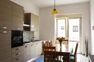 una cucina con un tavolo di legno e una sala da pranzo di Katospedi House a Lecce a Lecce