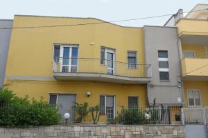 una casa gialla con balconi su una strada di Katospedi House a Lecce a Lecce