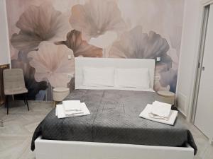 a bedroom with a bed with two towels on it at La Corte Guest House in Bari
