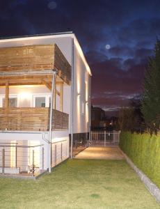 a white house with a deck at night at Villa Arkodes in Gdańsk