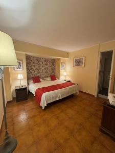 a large bedroom with a large bed with red sheets at A Casitta 2 Luxury Apartments in Taormina +3 photos