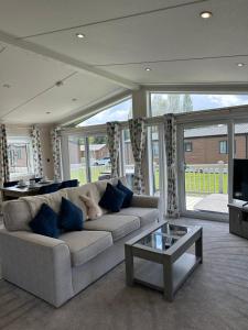 un salon avec un canapé et une table dans l'établissement Oakmont 4 - Lodge with Hot Tub, à Allerthorpe