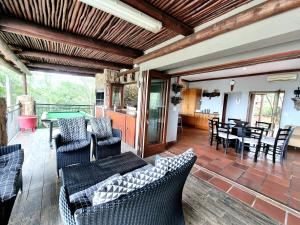 a patio with chairs and a table and a dining room at Lovely family home in the bush in Warmbaths