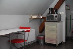 a small kitchen with a table and a microwave at Petit studio à la ferme à Mastaing in Mastaing