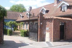 a red brick house with a black gate at Petit studio à la ferme à Mastaing in Mastaing