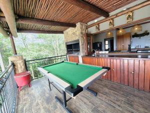 a room with a pool table on a balcony at Lovely family home in the bush in Warmbaths