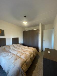 Un dormitorio con una cama grande y una mesa. en Departamentos Turquia Wifi, Tv, Aire y calefacción, en Oliva