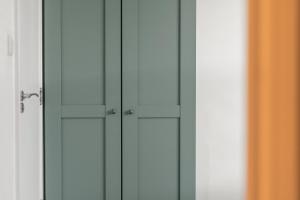 a closet with white cabinets and a mirror at Brand NEW 2 BR Fulham Apartment Near Tube Station COZY in London