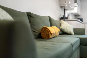 a yellow pillow sitting on a green couch at Brand NEW 2 BR Fulham Apartment Near Tube Station COZY in London