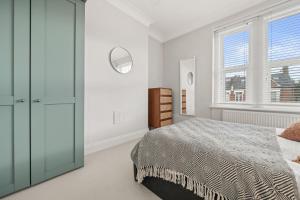a white bedroom with a bed and a window at Brand NEW 2 BR Fulham Apartment Near Tube Station COZY in London