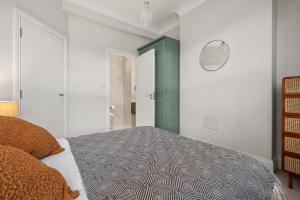 a bedroom with a bed and a green door at Brand NEW 2 BR Fulham Apartment Near Tube Station COZY in London