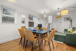 a dining room and living room with a table and chairs at Brand NEW 2 BR Fulham Apartment Near Tube Station COZY in London +16 photos