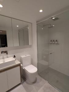 a bathroom with a shower and a toilet and a sink at FV PEPPERS Luxury City Apartment in Brisbane