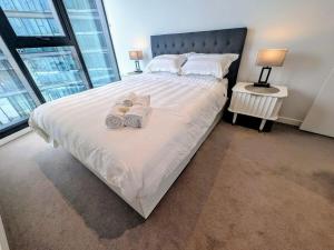 a bedroom with a large bed with slippers on it at FV PEPPERS Luxury City Apartment in Brisbane +30 photos