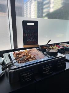 a tray of food on a table with meat and other foods at ibis Bucharest Politehnica in Bucharest