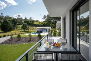 Un balcón con una mesa con fruta encima. en Villa Serenity - Between golf and the sea, en Foz do Arelho