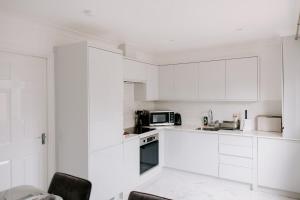 Thornaby on TeesにあるBadger Lane - 3 Bedroom House, parking and garden!の白いキッチン(白いキャビネット、電子レンジ付)