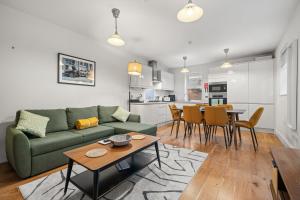 a living room with a green couch and a table at Brand NEW 2 BR Fulham Apartment Near Tube Station COZY in London