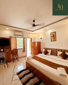 una camera da letto con un letto grande e una televisione di Hotel Laxmi Narayan a Rishikesh