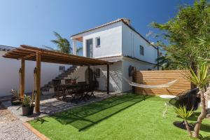 Un patio trasero con una hamaca y una casa. en Panorama Village, en Barbate