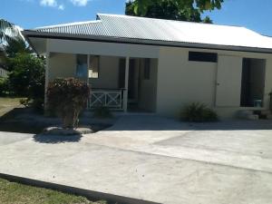 a small white house with a driveway in front of it at Pension Turiroa " Chez Olga" in Avatoru