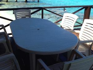 Pension Turiroa " Chez Olga" في أفاتورو: طاولة وكراسي زرقاء مع المحيط في الخلفية